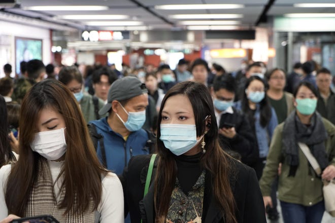 Passengers wear masks to prevent an outbreak of a new coronavirus in a subway station, in Hong Kong, Wednesday, Jan. 22, 2020. The first case of coronavirus in Macao was confirmed on Wednesday, according to state broadcaster CCTV. The infected person, a 52-year-old woman, was a traveller from Wuhan. [Kin Cheung/AP]