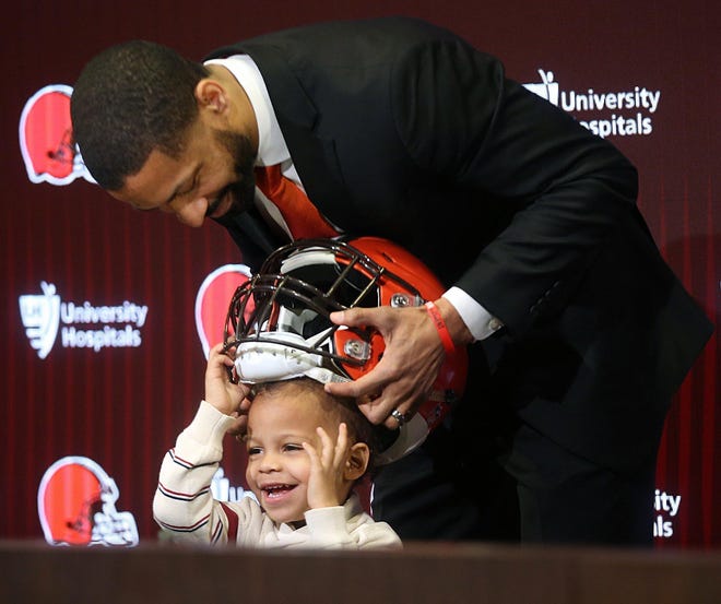 Browns general manager Andrew Berry places a helmet on his son Zion's head after his introductory news conference Wednesday. [Jeff Lange/Beacon Journal]