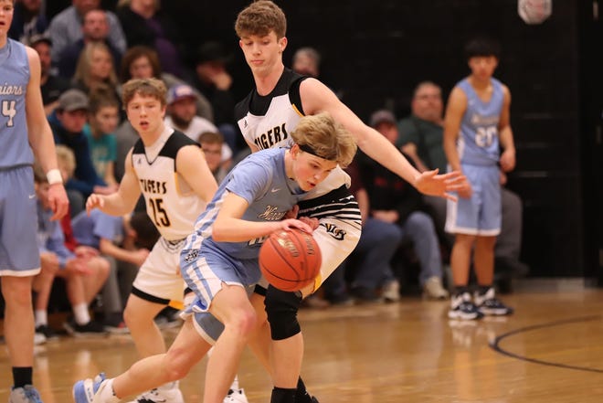 WACO's Drew Kissell (10) guarded by New London's Kade Benjamin Tuesday night at New London. [Dana Royer/Special to The Hawk Eye]