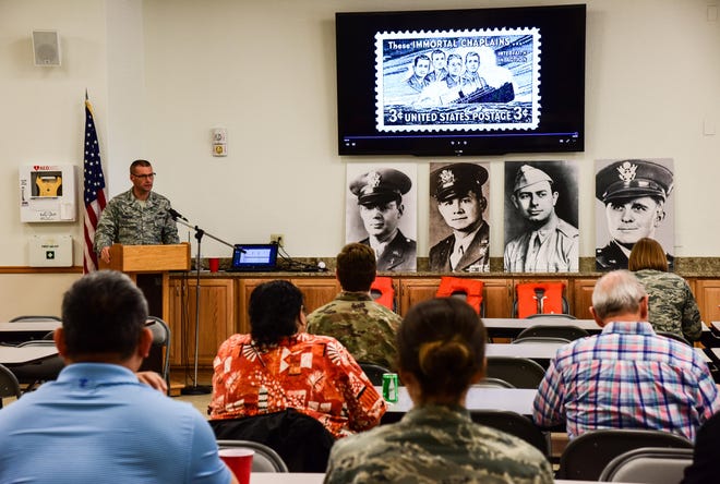 In this 2019 photo from McConnell Air Force Base in Kansas, Col. Phil Heseltine, 931st Air Refueling Wing commander, speaks during The Four Chaplain Ceremony. During the ceremony, an image of a stamp issued in 1948 by the U.S. Postal Service in remembrance of the four chaplains was displayed. [U.S. AIR FORCE]