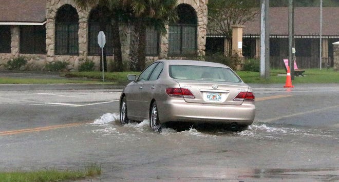 A car navigates a flooded intersection at Beach Street and Sickler Drive in Holly Hill as Hurricane Dorian passed through Daytona Beach in early September. For hoteliers, the storm erased the big Labor Day weekend and caused lingering business impact throughout the rest of 2019. [News-Journal/David Tucker]