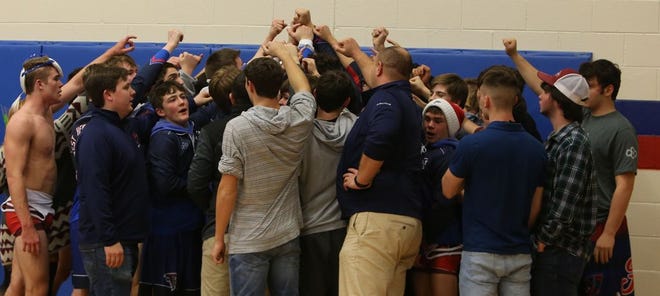In this file photo taken last month, the West Henderson High wrestling team celebrate after its win over Enka at West. [DEAN HENSLEY/ TIMES-NEWS]