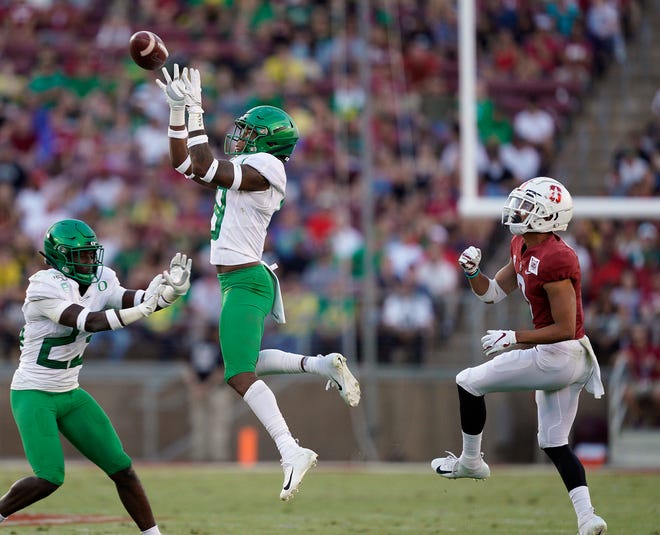 Oregon safety Jevon Holland (center) intercepts a pass in front of Stanford wide receiver Osiris St. Brown (right) while Oregon's Verone McKinley looks on during the second half of the Ducks' 21-6 win at Stanford on Sept. 21. [AP Photo/Tony Avelar]