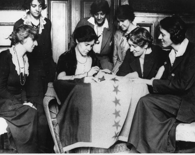 Celebrating ratification of the women's suffrage amendment, Alice Paul, seated second from left, sews the 36th star on a banner, in August of 1920. The banner flew in front of headquarters of the Women's Party in Washington of which Miss Paul was national chairperson. The 36th star represented Tennessee, whose ratification completed the number of states needed to put the amendment in the Constitution. [AP, file]