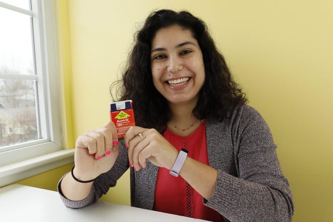 Emilia Louy holds an Auvi-Q epinephrine injector, an alternative to the EpiPen, that she keeps for her nut allergy at her Clintonville apartment. She‘s found a way to offset the cost of her medicine, but she still finds it unfair that companies are allowed to charge hundreds of dollars for the lifesaving medicine. [Adam Cairns/Dispatch]