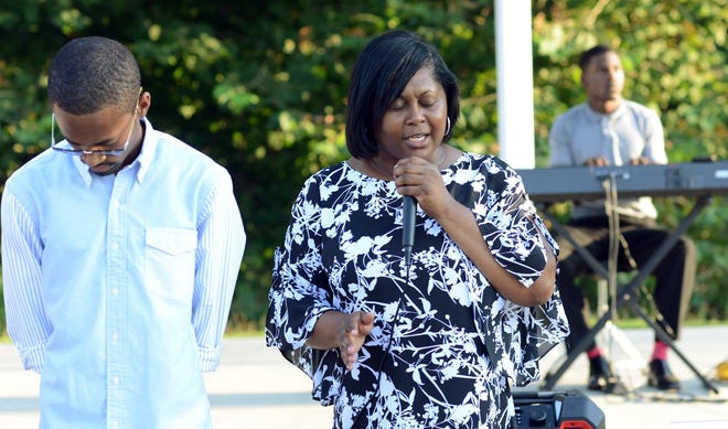 Kristal Suggs, Kinston City Council, and her son Chris, founder of Kinston Teens, pray at a Community Prayer Gathering at the Kinston Music Park. The group prayed for a successful school year for educators, school staff, students and the community. [Janet S. Carter / Free Press file photo]