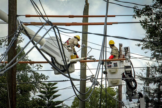Lakeland Electric power crews work on untangling and restoring power cables along Park Avenue near New York Avenue in the Dixieland area of Lakeland that were damaged by Hurricane Irma in September 2017. [ERNST PETERS/THE LEDGER]