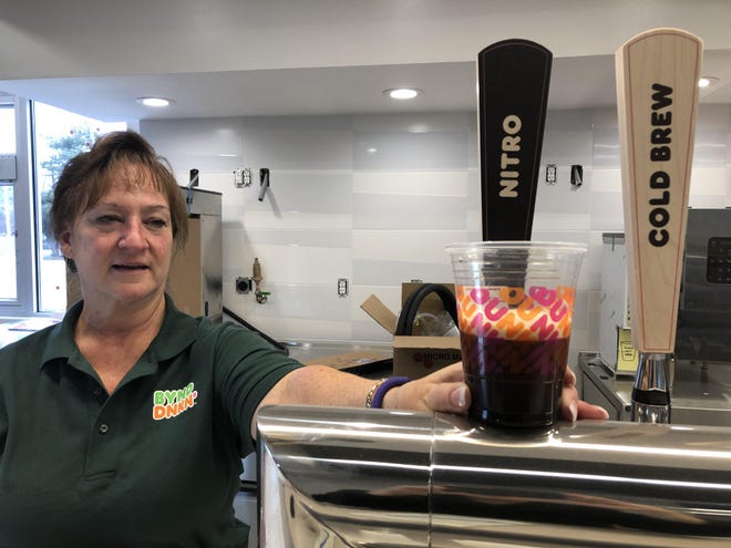 Dunkin’ franchisee Patty Babb holds up a sample of the Dunkin’ “Nitro” coffee on tap, a frothy, lightly effervescent cold brew coffee, in the new Dunkin’ location planned to open in Andover Township on Feb. 17. [Photo by Jennifer Jean Miller/New Jersey Herald (NJH)]