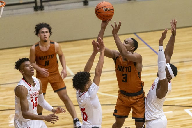 Hutto guard Jean-Pierre Sanders shoots over, from left, Manor’s Ay'keen Richardson, Tyrone Haywood and Jamal Shead during the Hippos’ 67-63 win Tuesday at Manor High School. Sanders had 16 points in the win. [Stephen Spillman for Statesman]