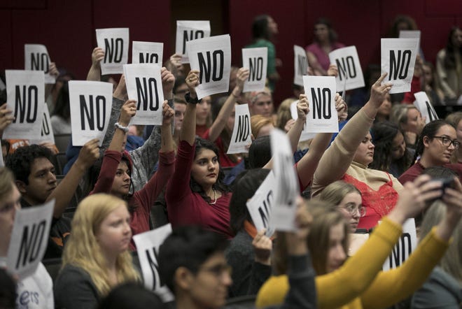 University of Texas students show their disagreement with answers to questions at a town hall meeting about sexual misconduct process and updates at UT in January. [JAY JANNER/AMERICAN-STATESMAN]