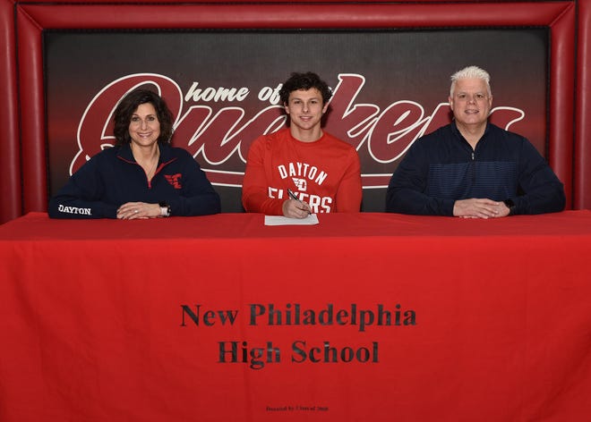 New Philadelphia senior John Sciarretti signs his letter of intent to play football Tuesday at the University of Dayton.Pictured with Sciarretti are his mother Lori and father John/ Photo courtesy of Joe Pry