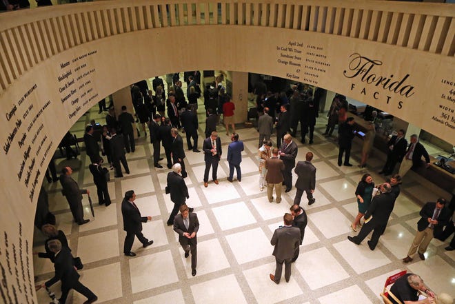Lobbyists work in the rotunda between the House and Senate chambers during session at the Capitol in Tallahassee, Fla. (AP Photo/Steve Cannon)