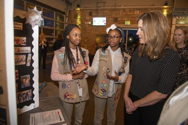Diamond White and Laila Gray explain their Silver Award project to Kristi Moore of JamisonMoneyFarmer at the Smart Cookie Girl Scout Award Ceremony at Riverside Market in Tuscaloosa on Tuesday, Feb. 11, 2020. Diamond and Laila worked with the Tuscaloosa Police Department to train officers how to respond to calls involving people on the autism spectrum. [Photo/Jake Arthur]