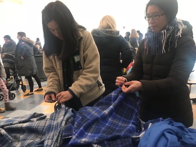 Wellesley High School students Chloe Gong and Hanna Chen make blankets for the homeless at Martin Luther King Jr. Day activities. [Wicked Local Staff Photo/Cathy Brauner]