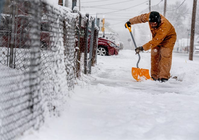 Denmark Thompson clears snow off the sidewalk in front of his South Peoria residence on Thursday. [MATT DAYHOFF/JOURNAL STAR]