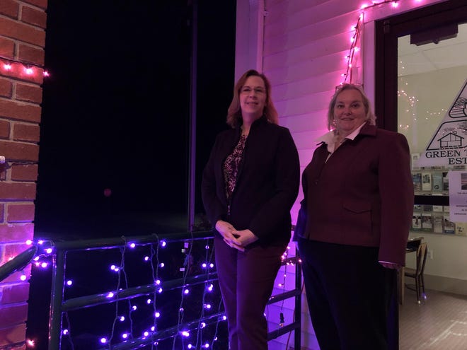 Standing in front of the main entrance to the Green Township Municipal Building on Tuesday, Feb. 11, from left to right Green Township Mayor Margaret “Peg” Phillips and Deputy Mayor Virginia “Ginny” Raffay, dress in purple, while surrounded with purple lighting, to mark the 100th anniversary of the ratification of the 19th Amendment, granting women the right to vote. [Photo by Jennifer Jean Miller/New Jersey Herald (NJH)]