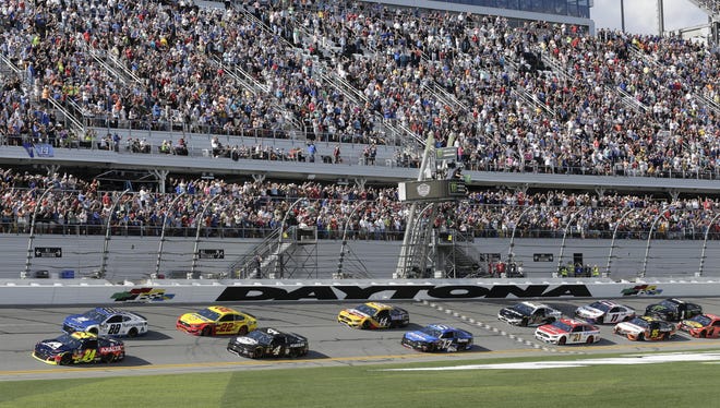 A packed crowd cheers as William Byron (24) and Alex Bowman (88) lead the field to start the 2019 Daytona 500 at Daytona International Speedway. The event will result in detours and expected delays on area roadways. [AP Photo]