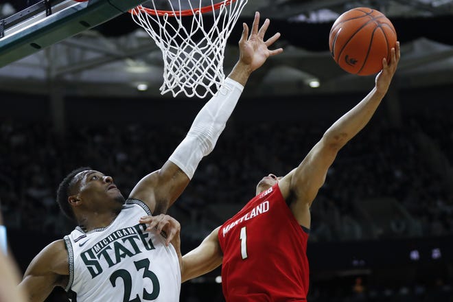 Maryland guard Anthony Cowan Jr. (1) drives on Michigan State forward Xavier Tillman (23) in the first half of an NCAA college basketball game in East Lansing, Mich., Saturday, Feb. 15, 2020. (AP Photo/Paul Sancya)