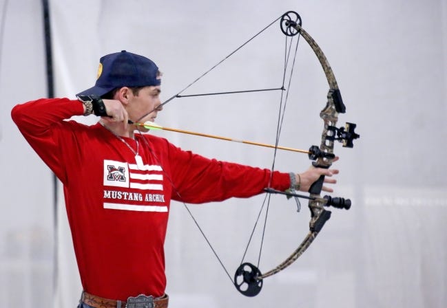 Caden Owens, a junior at Mustang High School, shoots in the varsity archery competition Wednesday during the Western Tier 2 state shoot at OKC State Fair Park. [SARAH PHIPPS/THE OKLAHOMAN]