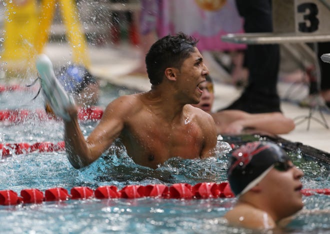Sheldon's AJ Iboa (center) celebrates his win in the boys 100-yard butterfly at the Southwest Conference district meet Saturday at Willamalane Swim Center in Springfield. [Chris Pietsch/The Register-Guard] - registerguard.com