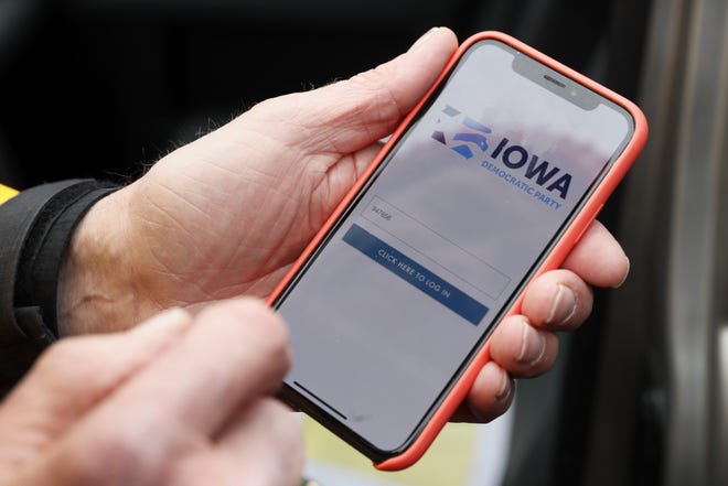 Precinct captain Carl Voss, of Des Moines, Iowa, holds his iPhone displaying the Iowa Democratic Party's caucus reporting app, Feb. 4 in Des Moines. [AP PHOTO/CHARLIE NEIBERGAIL]