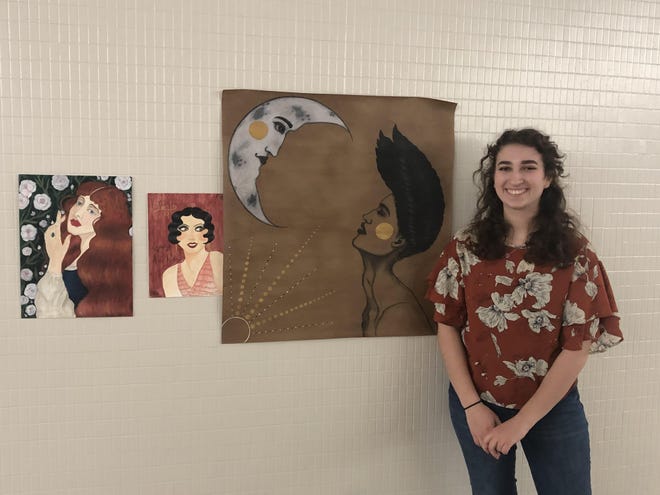 Alaina McCort displays work she has created during her art classes at Newcomerstown High. She said she enjoys drawing and painting people. (Times-Reporter photo / Joe Wright)