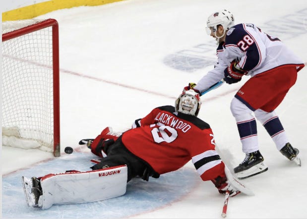 Columbus Blue Jackets right wing Oliver Bjorkstrand (28) shoots next to New Jersey Devils goaltender Mackenzie Blackwood (29) who made the save in overtime of an NHL hockey game, Sunday, Feb. 16, 2020, in Newark, N.J. The Devis won 4-3 in a shootout. [Kathy Willens/The Associated Press]