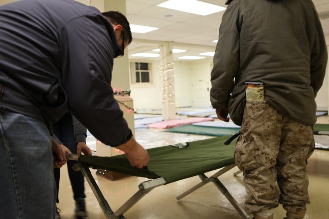 Volunteers set up cots and mats at an Egan Warming Center site. [Kelly Lyon/The Register-Guard file]