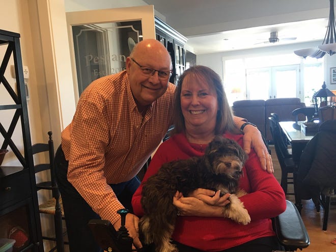 Louis and Linda Pestana smile with their new puppy Angel in their Tiverton home. [DEBORAH ALLARD/THE HERALD NEWS]