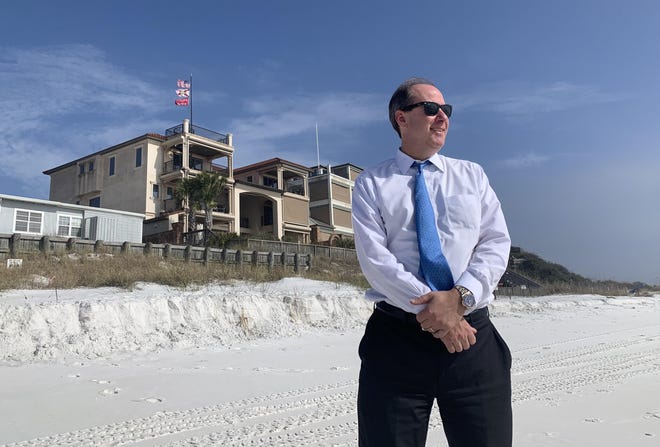 Attorney Daniel Uhlfelder poses on the South Walton beach behind the home of former Arkansas Gov. Mike Huckabee. [CONTRIBUTED PHOTO]