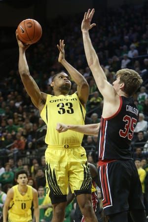Oregon's Francis Okoro shoots over Utah's Branden Carlson during the first half of Sunday's game at Matthew Knight Arena. [Chris Pietsch/The Register-Guard]