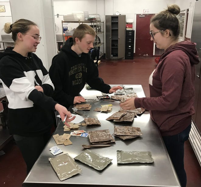Whittier Tech seniors Heather Twombly, of Haverhill, Jillian Marden, of Merrimac, and Jameson Bartholomew, of Haverhill, are shown practicing and getting familiar with the U.S. armed services MREs. [Courtesy Photo / Whittier Tech]