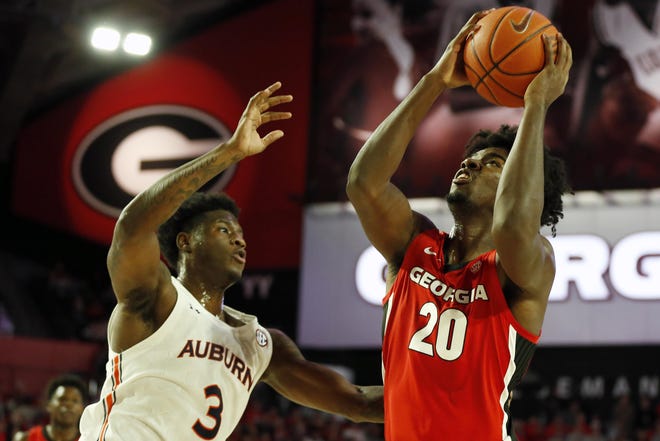 Georgia's Rayshaun Hammonds (20) takes a shot while being defended by Auburn forward Danjel Purifoy (3) during an NCAA basketball game between Auburn and Georgia in Athens on Wednesday. [Photo/Joshua L. Jones, Athens Banner-Herald]