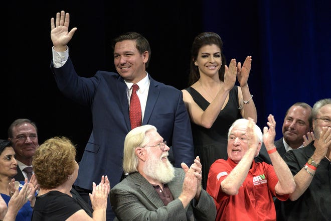 Gov. Ron DeSantis and his wife are acknowledged by President Donald Trump at a Medicare event held at the Sharon L. Morse Performing Arts Center in The Villages during Trump’s visit Oct. 3, 2019. DeSantis is speaking Friday at the Groveland Four monument dedication. [Cindy Sharp/Correspondent]