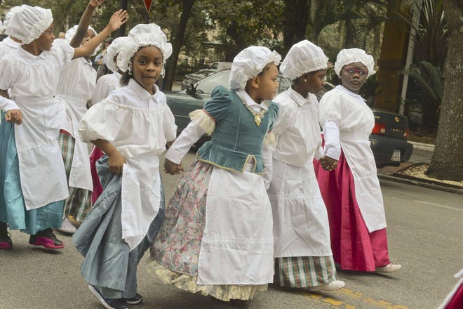 Girls dressed in Colonial garb from Gadsden Elementary School wave to bystanders in the 2018 Georgia Day Parade. (Steve Bisson/Savannah Morning News)