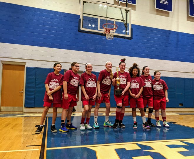 From left, Holy Trinity players Ella Viramontess, Abigail Lobis, Isabella DiMattia, Addison Holmes, Ellenmarie Buck, Ariella Parks, Molly Snyder and Jessica Naphy celebrate with the trophy after winning the CYO Region 19 championship. Not pictured are Illyana Medina and Abigail Nix. [CONTRIBUTED]