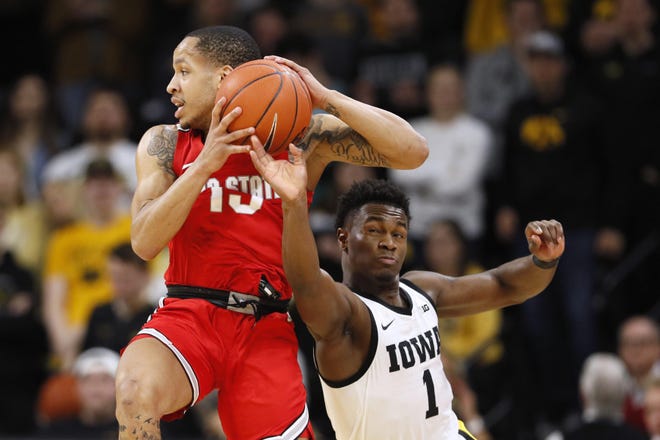 Iowa guard Joe Toussaint (1) tries to steal the ball from Ohio State guard CJ Walker, left, during the second half of an NCAA college basketball game, Thursday, Feb. 20, 2020, in Iowa City, Iowa. Iowa won 85-76. (AP Photo/Charlie Neibergall)