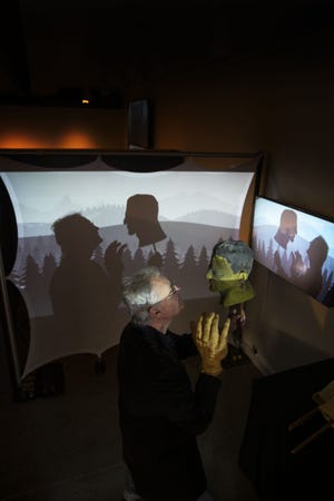 Artist Todd Bokich plays with his creation “Silhouettes & Shadows," a multimedia creation that invites visitors to create their own puppet show within a projection booth. [Chris Pietsch/The Register-Guard] - registerguard.com