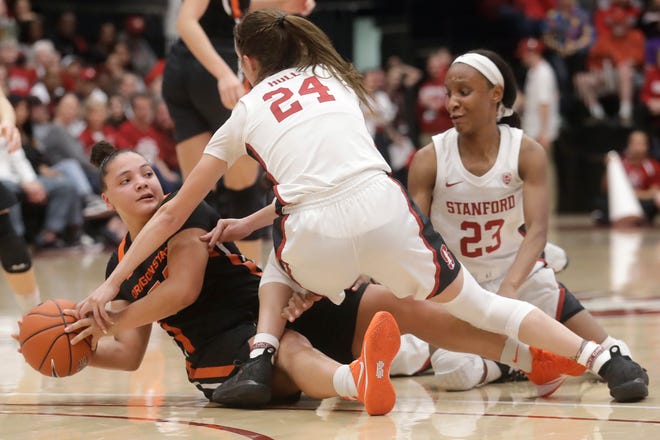 Oregon State guard Destiny Slocum tries to pass the ball while being defended by Stanford guard Lacie Hull (24) and guard Kiana Williams (23) during the second half of Friday's game. Slocum had a season-high 26 points, but Stanford won 63-60. [AP Photo/Jeff Chiu]
