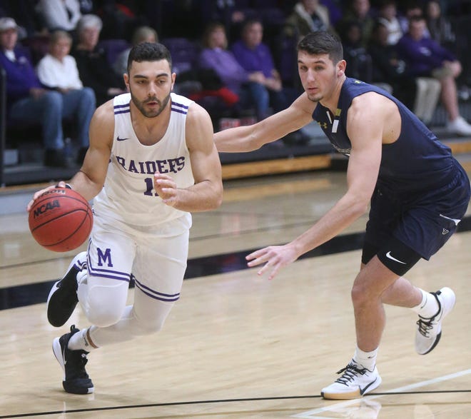 Mount Union's D'Vontay Friga drives to the basket while being guarded by John Carroll’s Mason Trubisky (5) during the first half of their game at Mount Union in January. Friga scored 24 points for the Purple Raiders in Saturday’s win over Capital. (CantonRep.com / Scott Heckel)