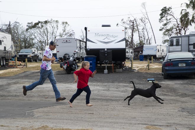 Chris Brockman, Kaydee Johnson, 9, and their dog Daisy race down the road in front of their trailer provided by FEMA on Wednesday, February 20, 2019. [JOSHUA BOUCHER/THE NEWS HERALD] \r