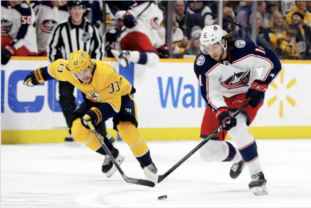 Blue Jackets center Kevin Stenlund moves the puck ahead of Predators right wing Viktor Arvidsson in the first period of Saturday night’s game. [Mark Humphrey/The Associated Press]