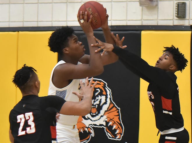 LIncoln Park's Montae Reddix tries to shoot through two Aliquppa players during their game Monday at North Allegheny High School. [Lucy Schaly/For BCT]