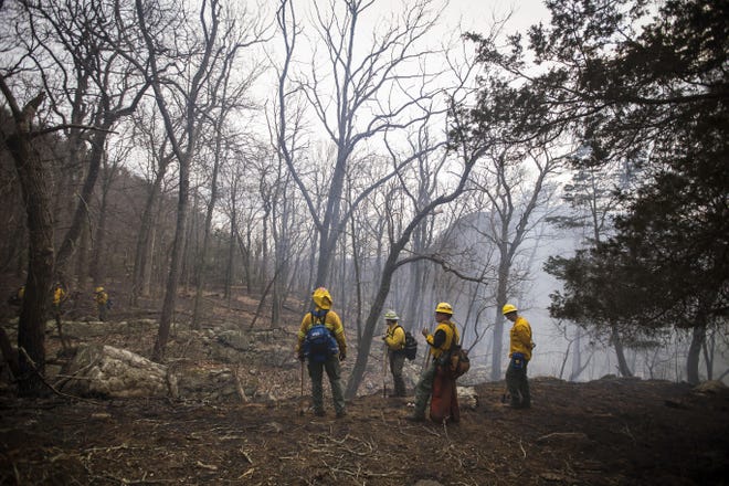 Firefighters with the New Jersey Forest Fire Service standing near the lower peak of Mount Tammany monitor the remaining pockets of flames below following a wildfire that began Sunday and spread throughout the area into Monday in the Delaware Water Gap National Recreation Area in Hardwick. [Photo by Daniel Freel/New Jersey Herald (NJH)]