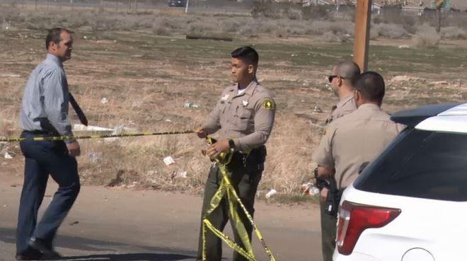 In this screen grab from video, San Bernardino County Sheriff’s Department officials tape off a crime scene outside a home in Adelanto where authorities say three people were shot on Sunday, Feb. 23, 2020. The Sheriff’s Department identified the shooter and two deceased victims on Monday. [SCREEN GRAB COURTESY OF LEWIS BUSCH]