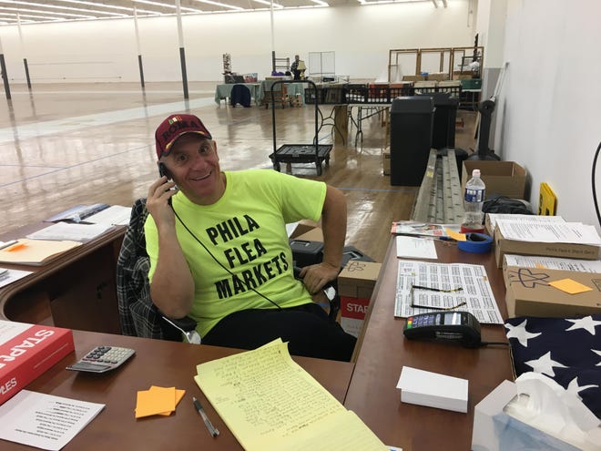 Tony Soprano, proprietor of Phila Flea Markets, takes one of several calls from vendors preparing to sell goods at the former Walmart store in Bristol’s Commerce Park when the flea market opens this weekend. [PEG QUANN / STAFF PHOTOJOURNALIST]