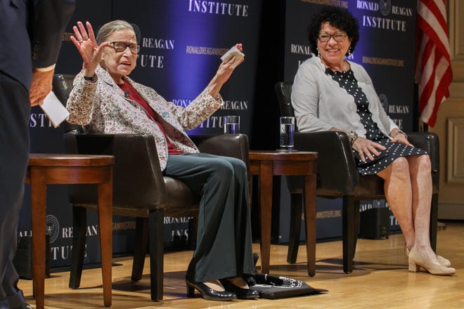 In this Sept. 25, 2019 file photo, Supreme Court Justice Ruth Bader Ginsburg, left, holds up her hands as she and Supreme Court Justice Sonia Sotomayor arrive to applause for a panel discussion celebrating Sandra Day O'Connor, the first woman to be a Supreme Court Justice, at the Library of Congress in Washington. A month before the Supreme Court takes up cases over his tax returns and financial records, President Donald Trump on Tuesday made the unusual suggestion that two liberal justices should not take part in those or any other cases involving him or his administration. [JACQUELYN MARTIN/ASSOCIATED PRESS]