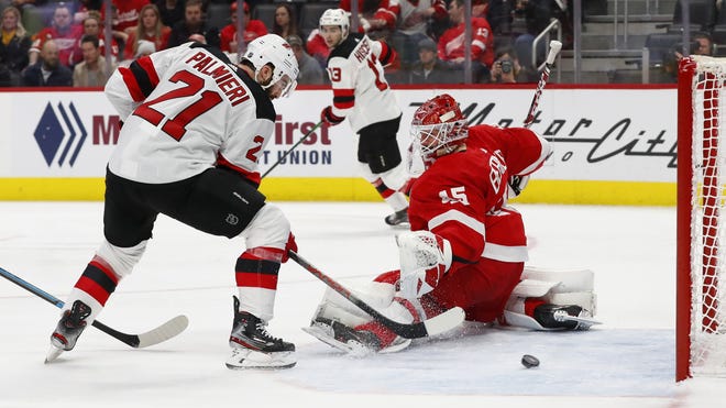 New Jersey Devils right wing Kyle Palmieri (21) scores a goal on Detroit Red Wings goaltender Jonathan Bernier (45) in the second period of an NHL hockey game Tuesday, Feb. 25, 2020, in Detroit. (AP Photo/Paul Sancya)