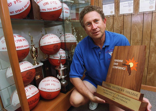 Florida Southern Women's basketball coach Norm Benn with several trophies as well as balls representing players he coached who scored over 1000 points during their college play under him. [LEDGER FILE 1997]