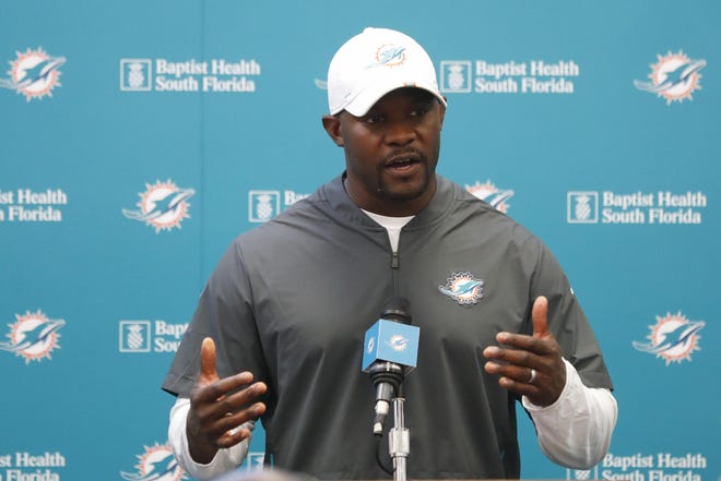 Miami Dolphins head coach Brian Flores speaks to members of the media before the start of practice at the NFL football team's training camp, Monday, Aug. 19, 2019, in Davie, Fla. Ryan Fitzpatrick is expected to start the Miami Dolphins' exhibition game this week, which suggests he's still the front-runner in his battle with Josh Rosen for the starting job. (AP Photo/Wilfredo Lee)